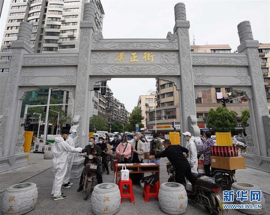  4月16日，進(jìn)出武漢漢正街步行街的人員在掃描健康碼。新華社記者 王毓國 攝